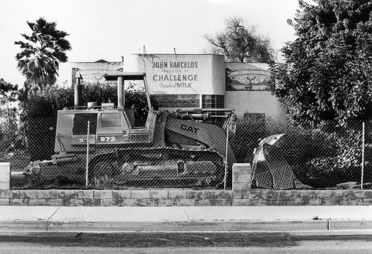 Image of workmen tearing down a house and store.